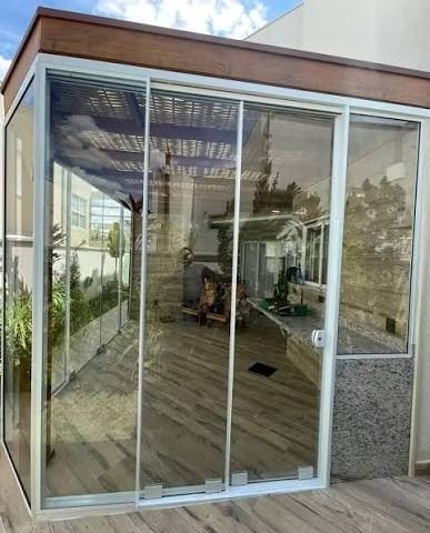 Porta de vidro temperado pivotante instalada em residência em Campinas