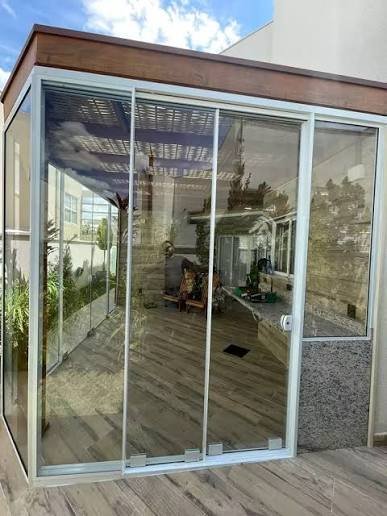 Porta de vidro temperado pivotante instalada em residência em Campinas