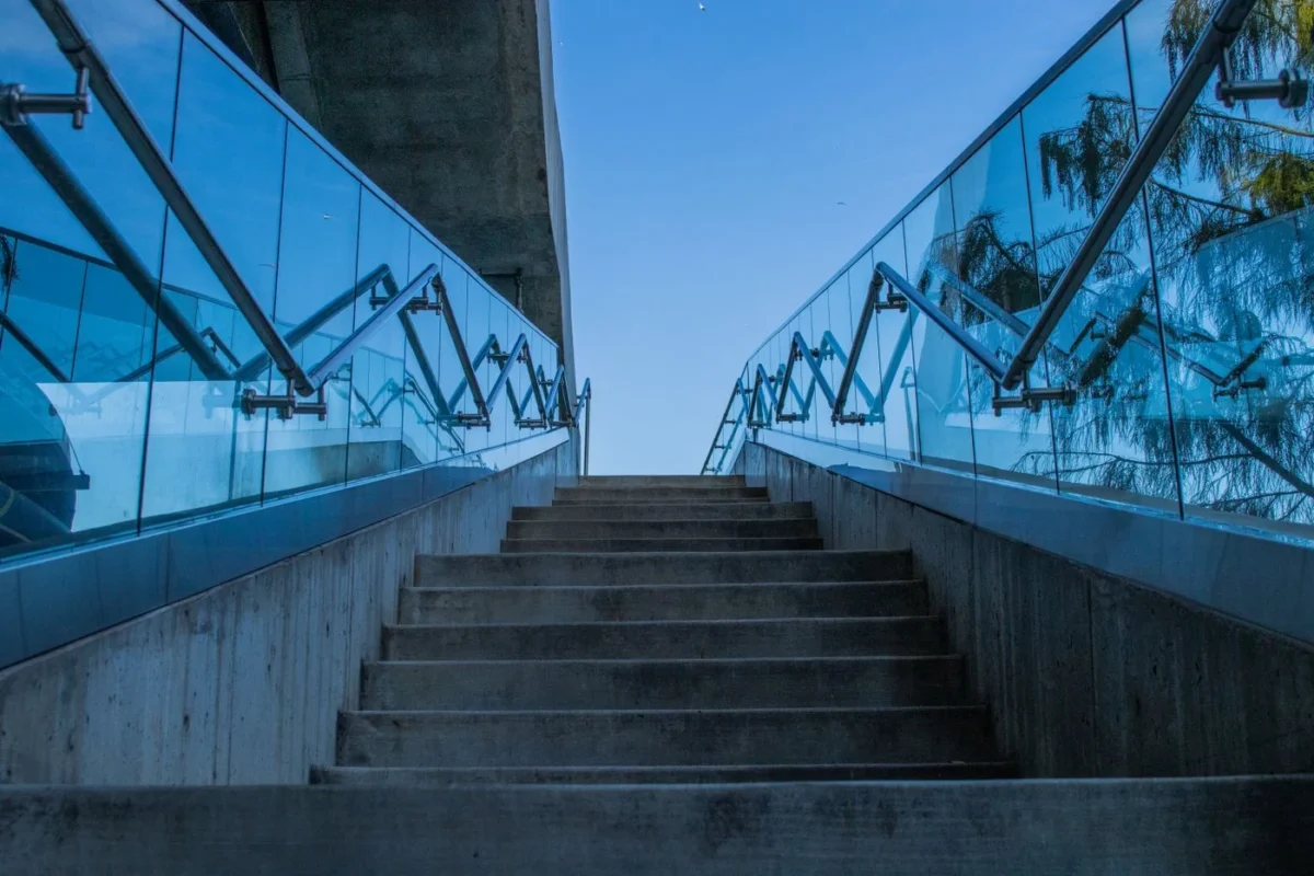 Escada de concreto com guarda-corpo de vidro vista de baixo
