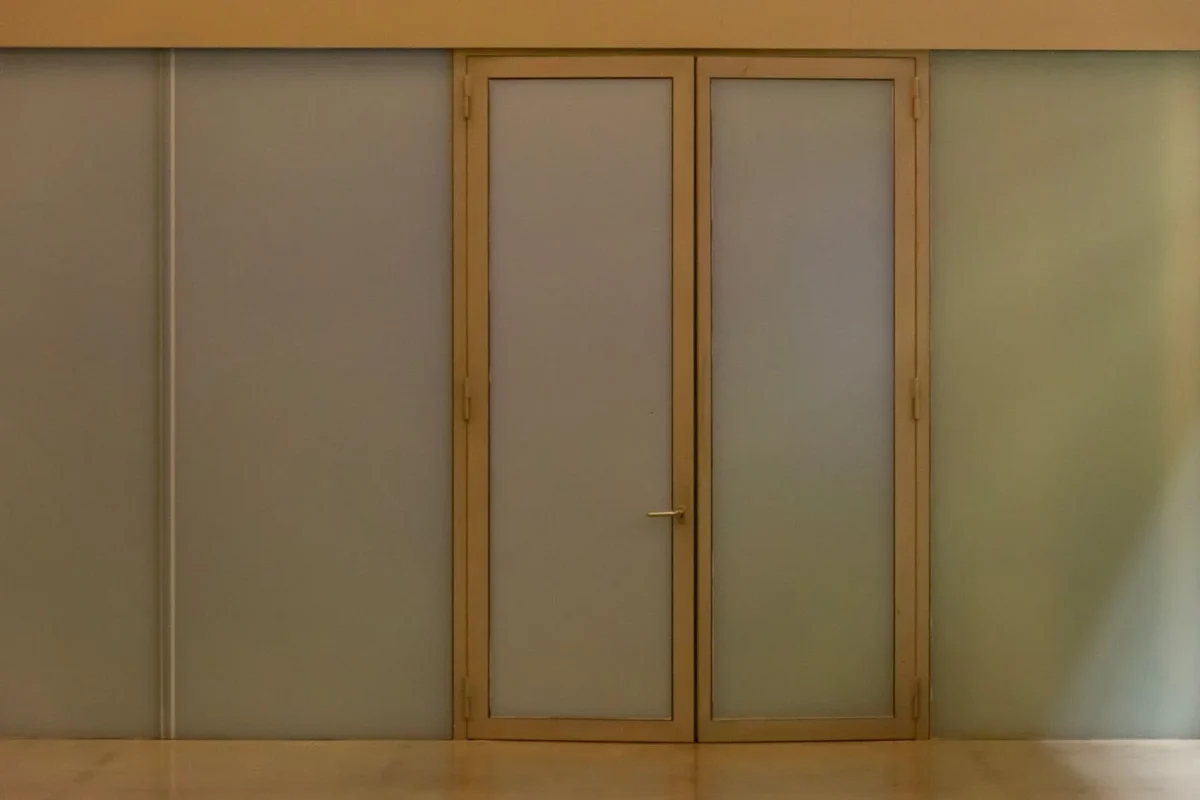 Porta bege com painéis de vidro fosco em ambiente interno