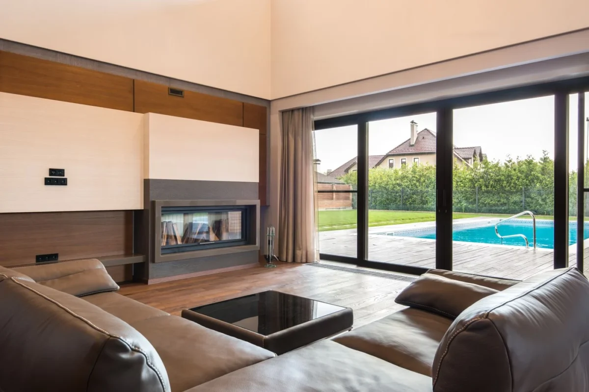 Sala de estar com portas de vidro que abrem para a área da piscina
