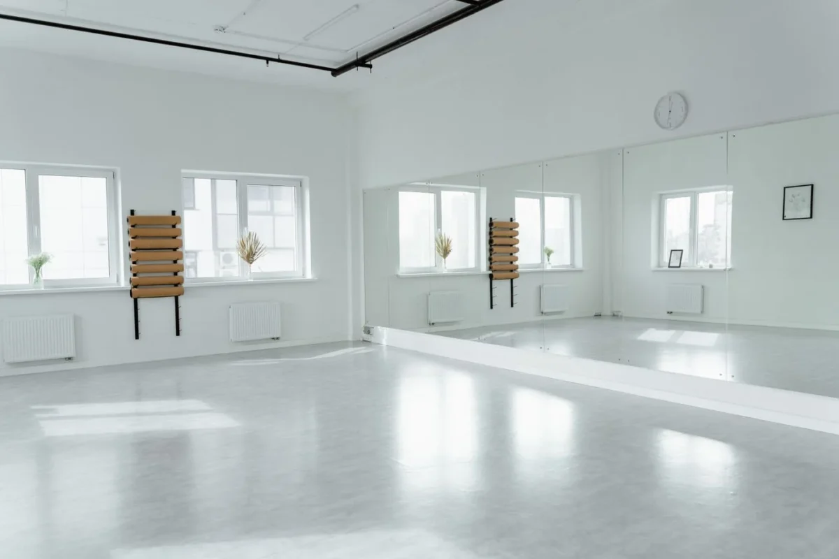 Sala ampla e clara com grande espelho na parede e janelas